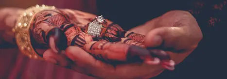 The bride and groom holding hands during the rituals of an Indian wedding.
                